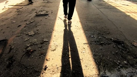 Shadow of a man exiting spooky, abandoned building in sunset. Rear view. Stock Footage 89293420