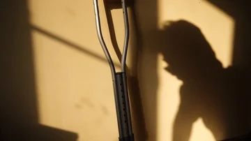 Shadow of a man getting up with crutches Stock Footage 85972307