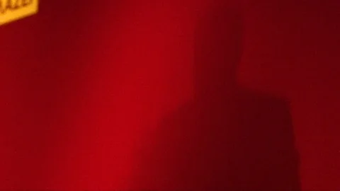 The shadow of a man giving a speech in a red backdrop  Stock Footage 120443059