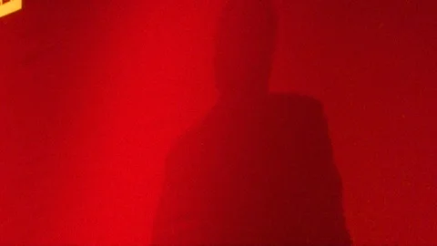 The shadow of a man giving a speech in a red backdrop Stock Footage 120443227