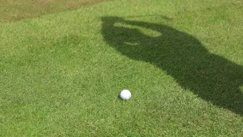 The shadow of the man on a golf course hits the ball with a club 스톡 동영상 169907941