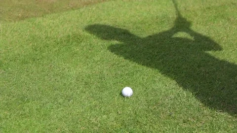 The shadow of the man on a golf course hits the ball with a club Video stock 179514795