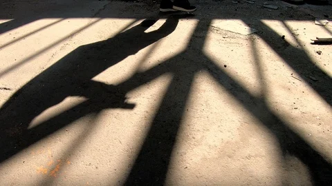 Shadow of a man with gun sneaking in spooky, abandoned building 動画素材 88348892