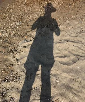 Shadow of a man with hat at the beach Stock Photos