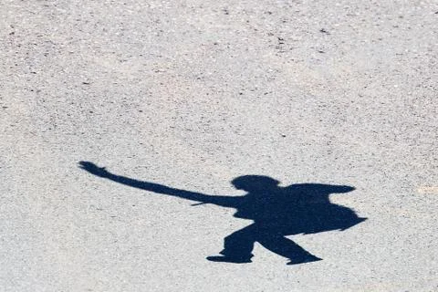 Shadow of a man jumping on the asphalt Stock Photos