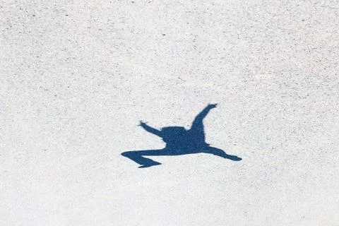 Shadow of a man jumping on the asphalt Foto stock