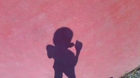 The shadow of a man in a Panama hat drinking from a bottle 動画素材 342097405