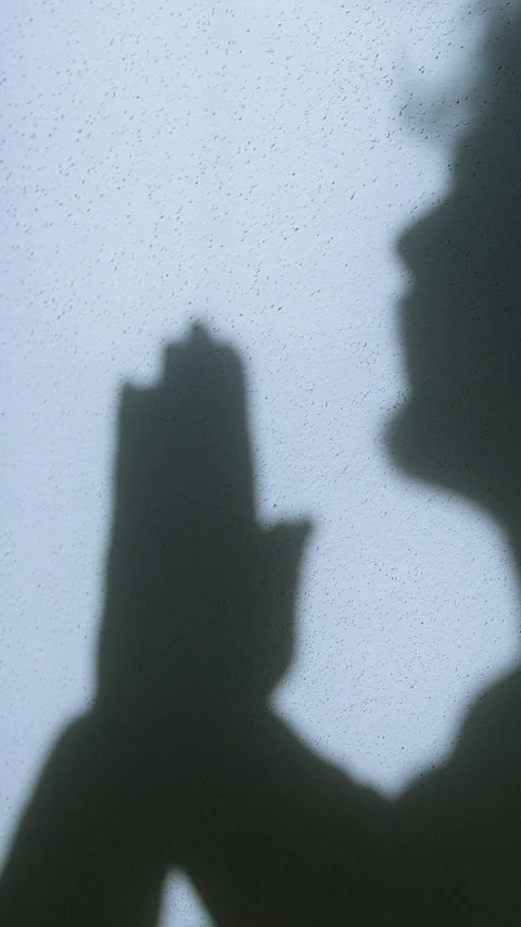 Shadow of a man in prayer with hands clasped in Christian devotion, symboli.. Stock-Footage 303750294