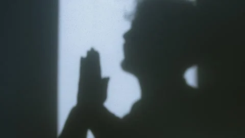 Shadow of a man in prayer with hands clasped in Christian devotion, symboli.. Stock-Footage 303943326