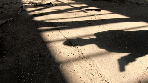 Shadow of a man pulling out gun  in spooky, abandoned building Stock Footage 88353386