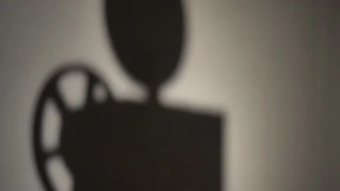 Shadow of a man putting on a reel on the projector, and starts it. Stock Footage 138955289