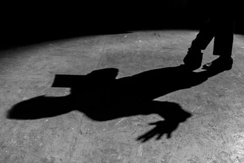 Shadow of a man reading a newspaper under a lantern Stock Photos