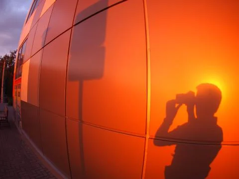 The shadow of a man on a red-orange wall Stock Photos