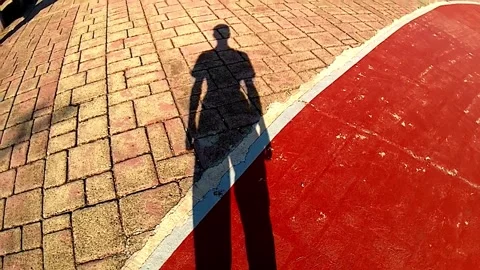 The shadow of a man on the road walking forward 動画素材 336678440
