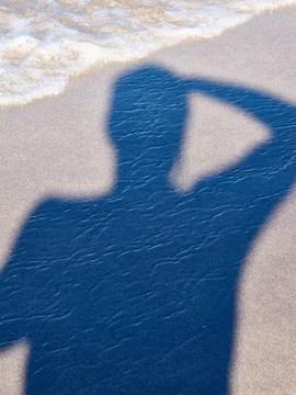Shadow of a man standing at the beach Stock Photos