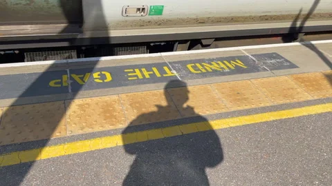 Shadow of man stands by platform as train arrives 動画素材 152937966
