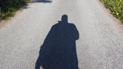 The shadow of a man walking across the road alone Stock Footage 119453708