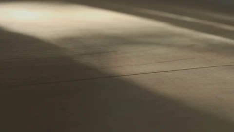 Shadow of a man walking back and forth on wooden parquet floor Stock Footage 107656531
