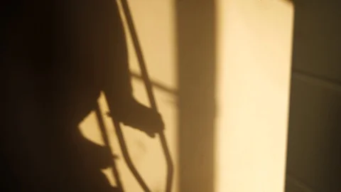 Shadow from man walking with crutches Stock Footage 85972250