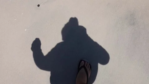 Shadow Of A Man Walking On Sand Towards Beach On A Sunny Day Video stock 166650437