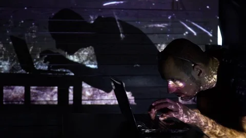 The shadow of a man working at a computer with fireworks 스톡 동영상 99698852