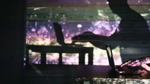 The shadow of a man working at a computer Video stock 99041813