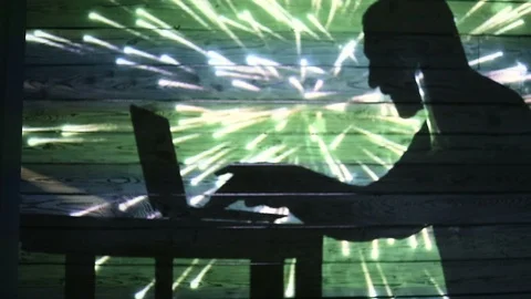 The shadow of a man working at a computer Stock Footage 99042453