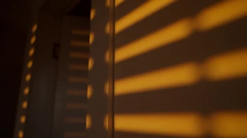 Shadow of mechanical rolling window blinds or shutters rolling down on wall Stock Footage 308618186