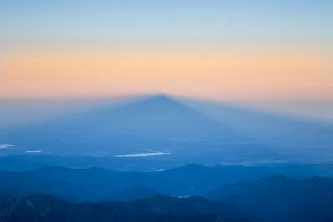 Shadow of a mountain peak at sunrise Stock Photos