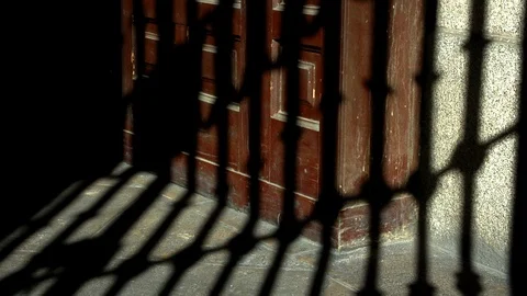 Shadow o a grille moving along a wooden door. Time lapse Stock Footage 113056554