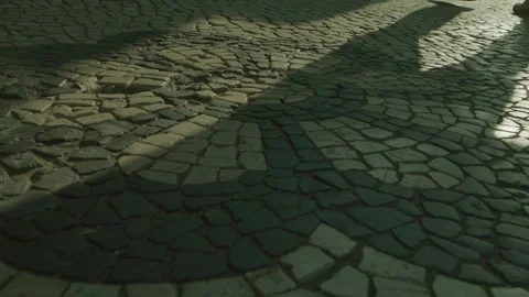 Shadow from a pedestrian walking on stone paving stones Stock Footage 273781179