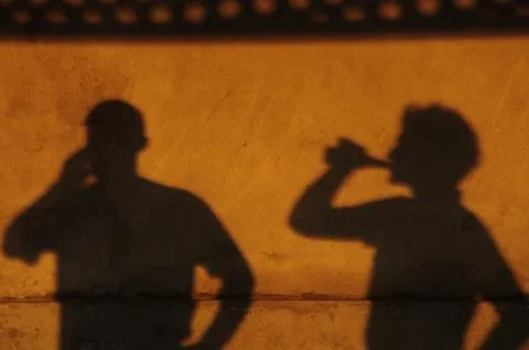 Shadow of people drinking on a yellow wall. Stock Photos