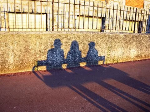 Shadow of people resting on a bench Stock Photos