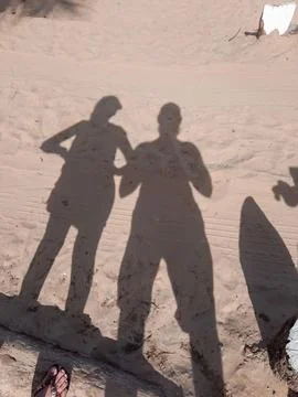 Shadow of people on the sand of the beach Stock Photos