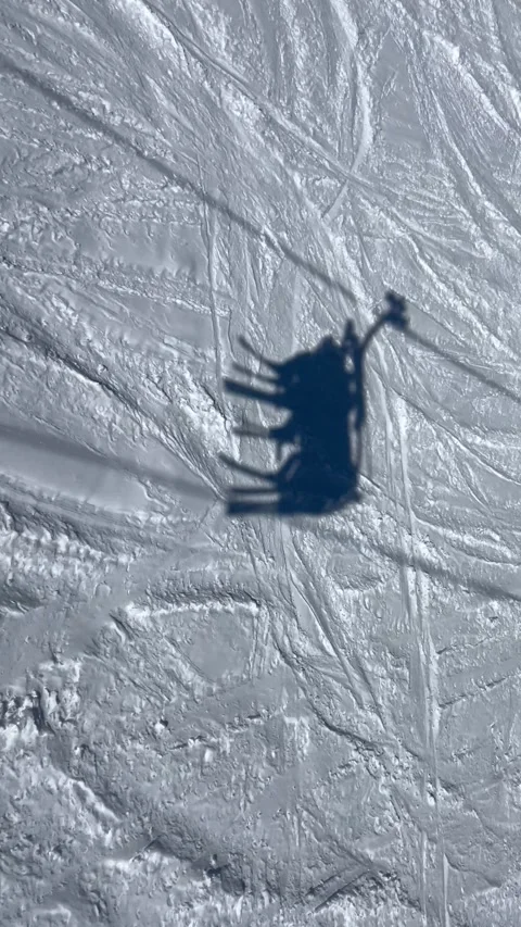 Shadow of People on ski lift over the snowy slopes Stock Footage 336927675