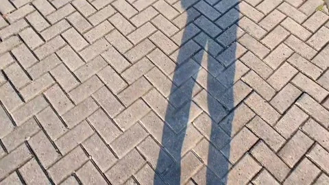 The shadow of people walking.on paving block road Stock Footage 288268667