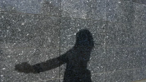 Shadow of a person posing dancing on a granite wall background Stock Footage 292732943