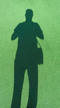 Shadow of a photograph of a bag projected onto green synthetic grass in the s Stock Photos