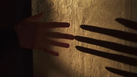 Shadow play. Shadow of the hand plays on the wall in orange light Video stock 100038177