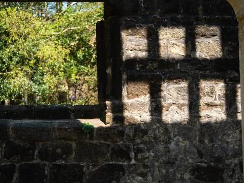 Shadow of prison bars on a stone wall Stock Photos