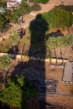 Shadow of Pulicat lighthouse falling over the park nearby during the sunset Stock Photos