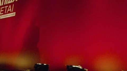 The shadow on a red backdrop of a man talking in front of a podium - abstract Stock Footage 120468181