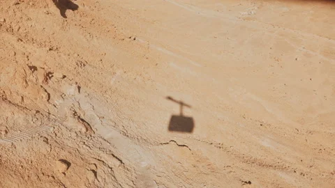 Shadow of a ropeway cabin rising in Masada desert. Aerial cable car going up on Vídeo Stock 86401211