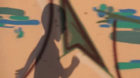 Shadow of a running boy falls on a wall with graffiti Stock Footage 84201299