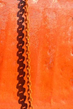 Shadow of a rusty metal chain on on a rusty steel surface, reddish background Stock-Fotos