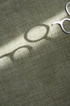 Shadow of scissors on green fabric 스톡 사진