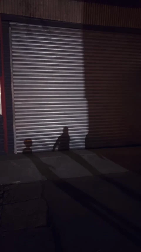 Shadow silhouette of children playing with balloon on garage door at night,.. Stock Footage 333387892