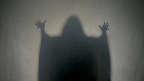 Shadow silhouette of a dark halloween ghost dancing in fog behind the glass Stock Footage
