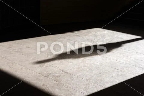 A shadow of a single person on a tiled floor Stock Photos