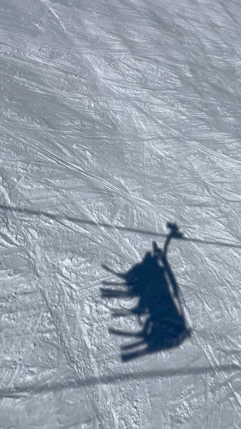 Shadow of a Ski lift going up on the slopes of Courchevel ski resort Stock Footage 336927658